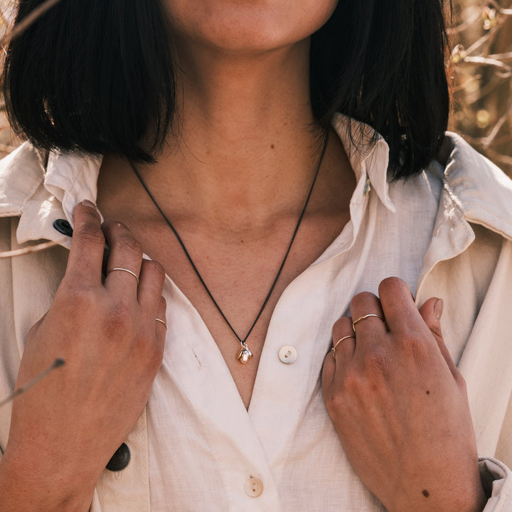 ocean pebble necklace worn with white shirt and white jacket