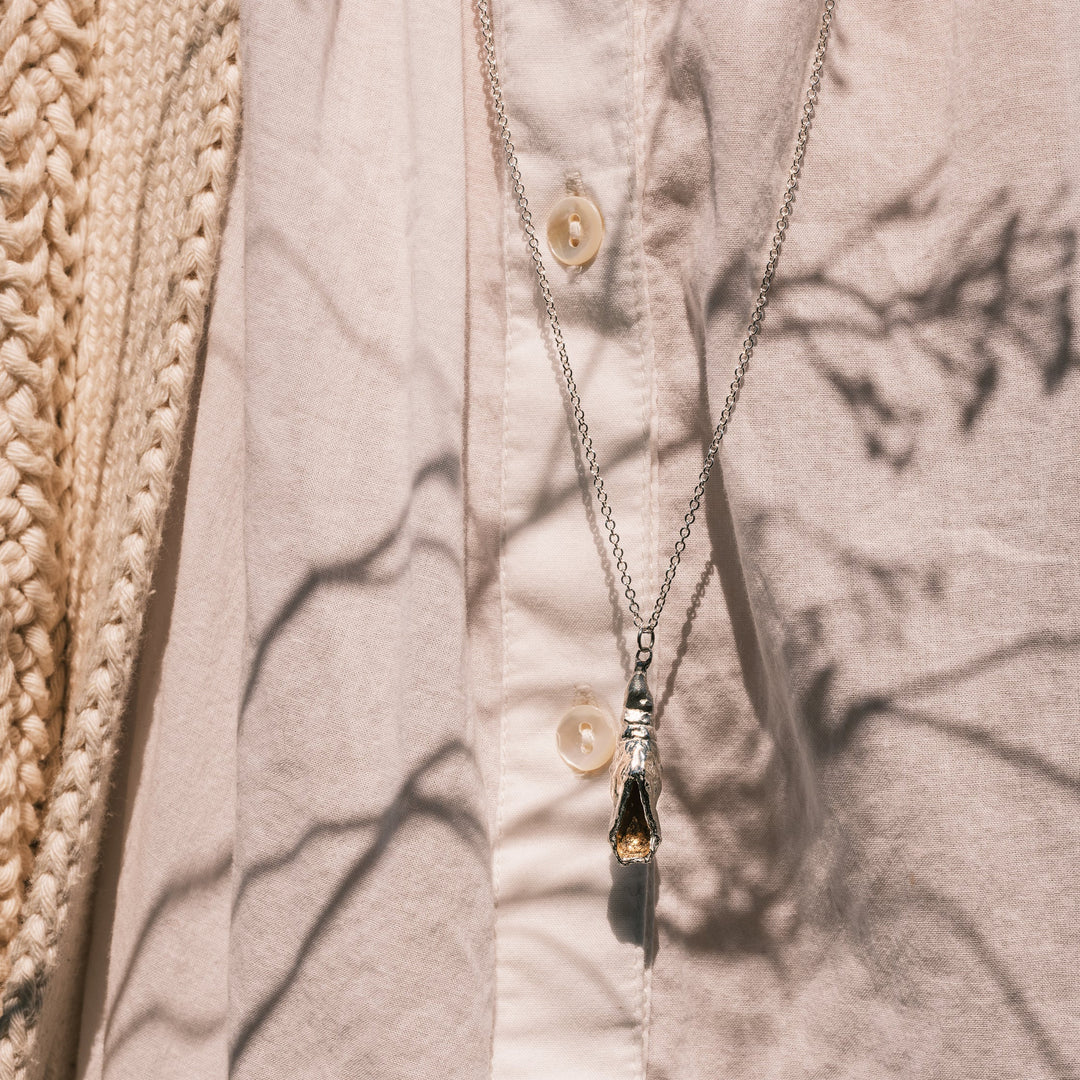 swallowtail chrysalis necklace on white shirt, goldenrod shadow