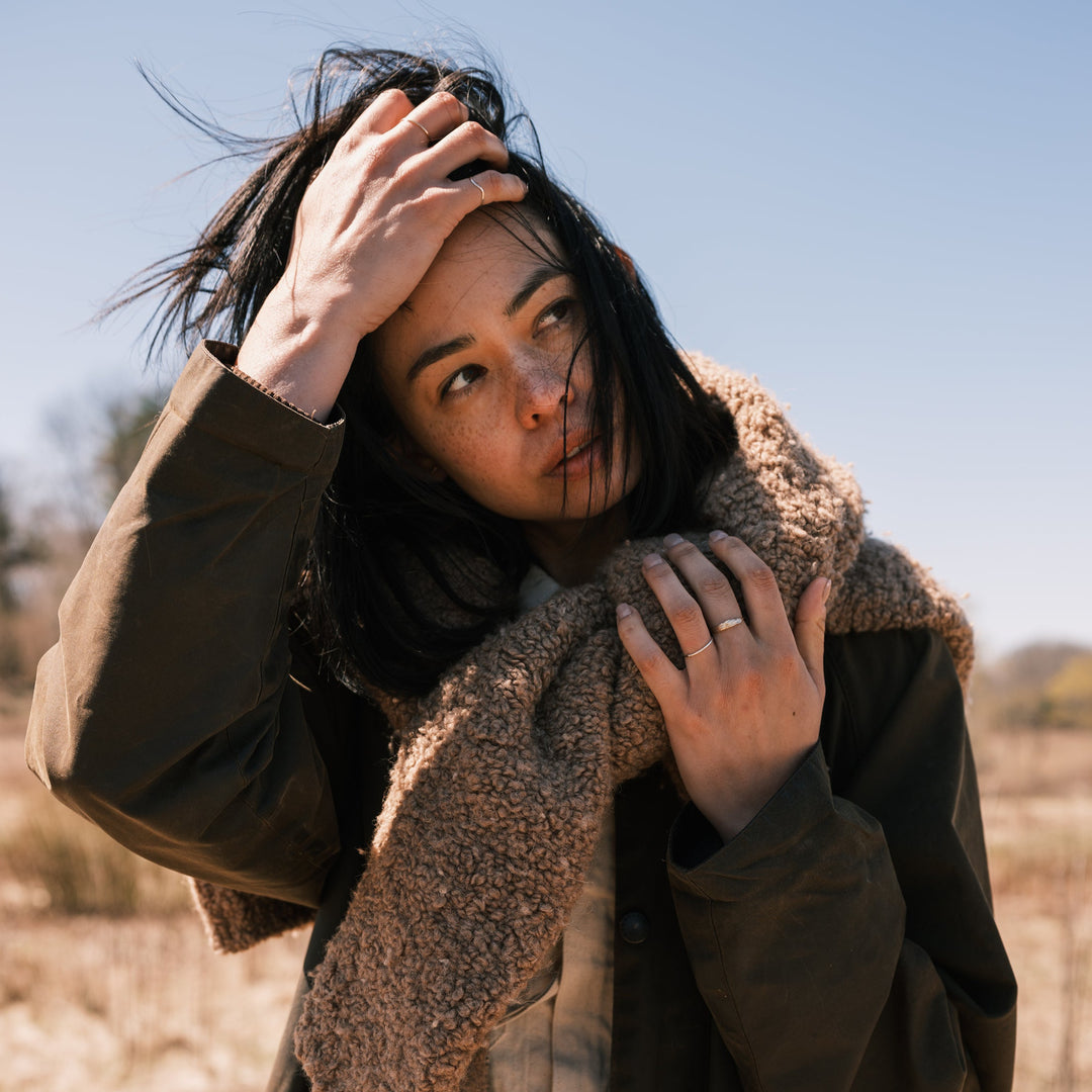 model wearing thicket rings, waxed canvas jacket and sweater