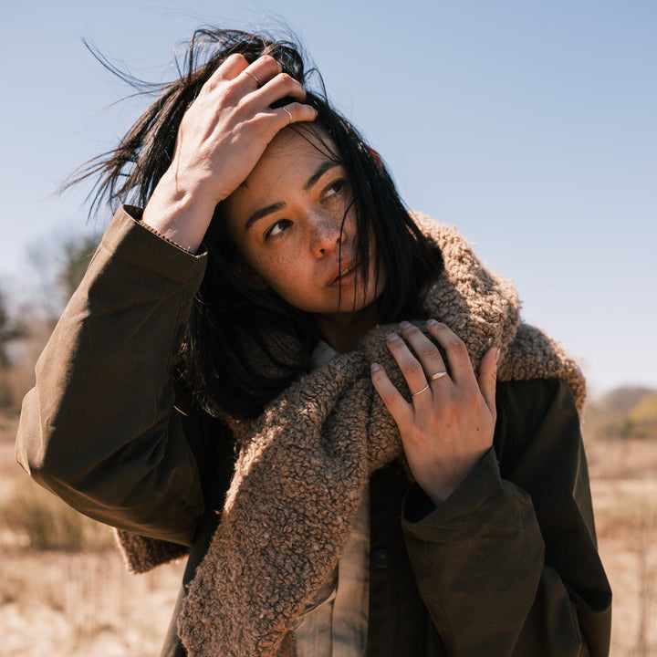 model wearing thicket rings, waxed canvas jacket and sweater