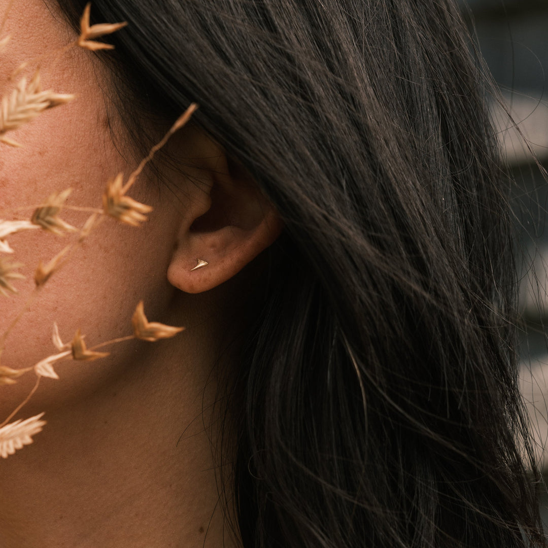 close up of model wearing gold blackberry thorn studs