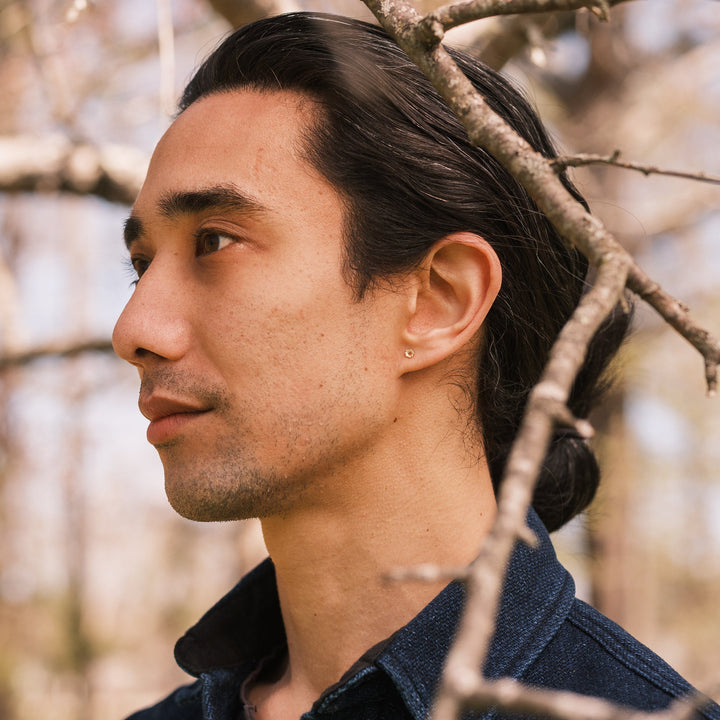 crinoid fossil stud worn with indigo blue shirt
