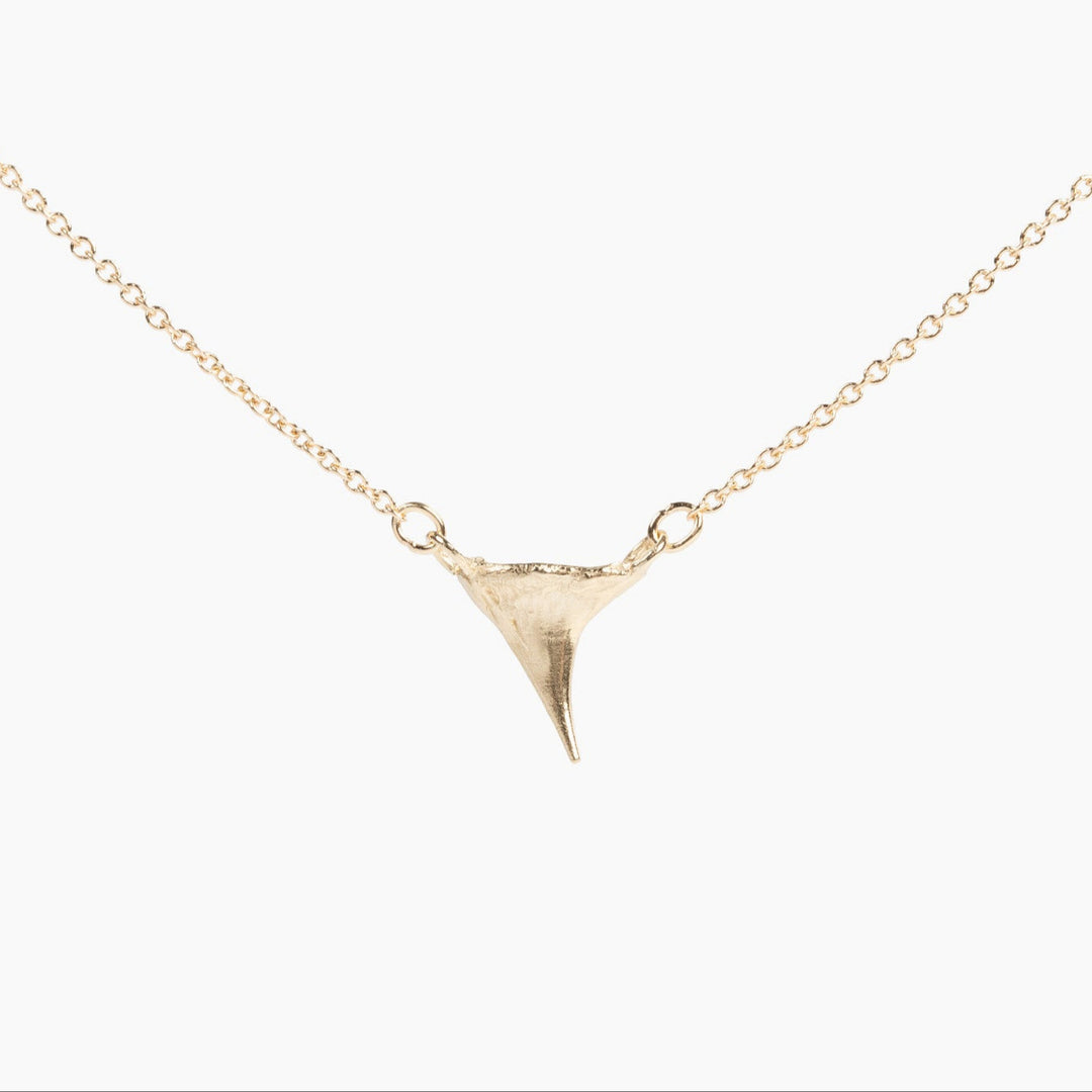 Thicket gold rose thorn necklace on a white background