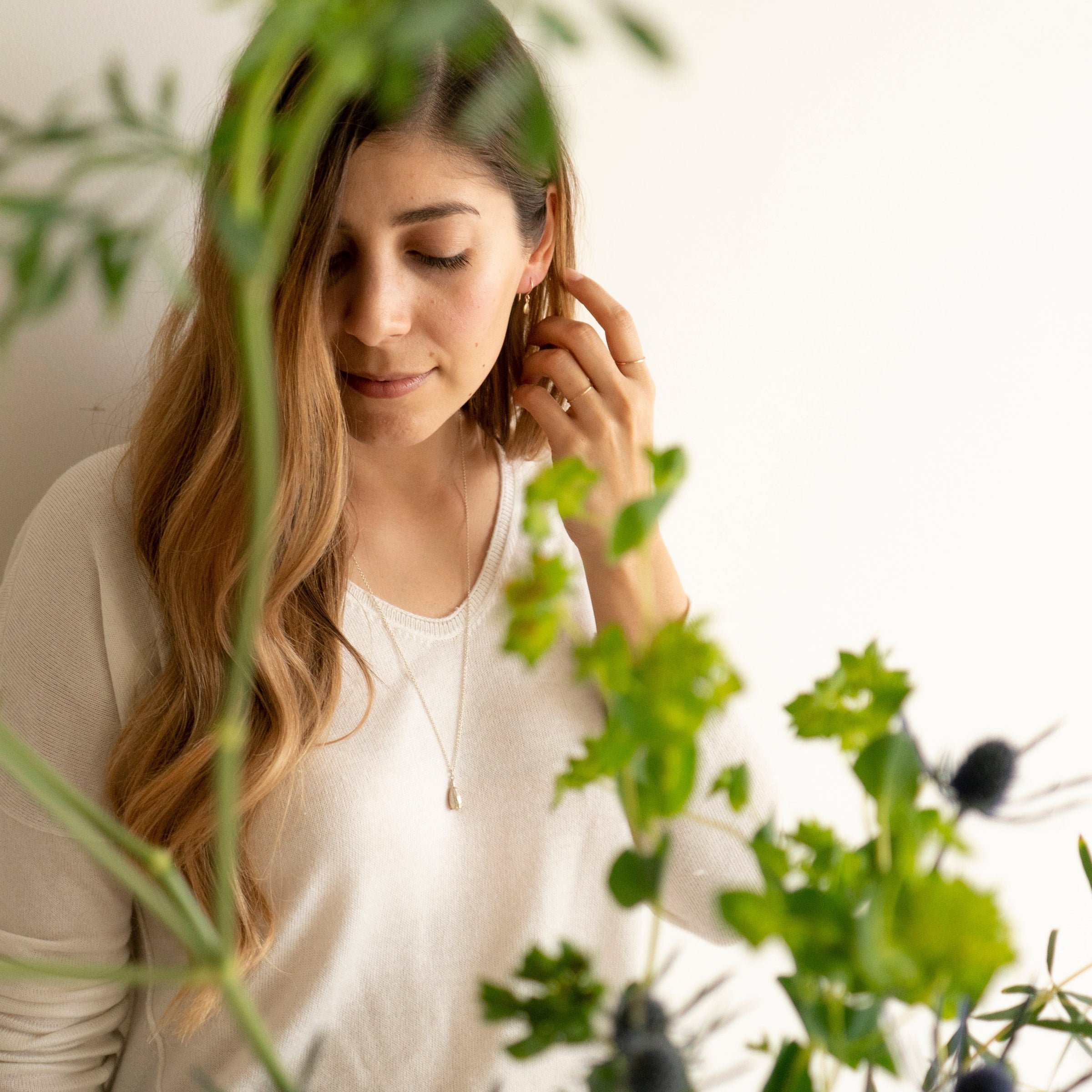 model wearing Thicket's poppy seed pod necklace
